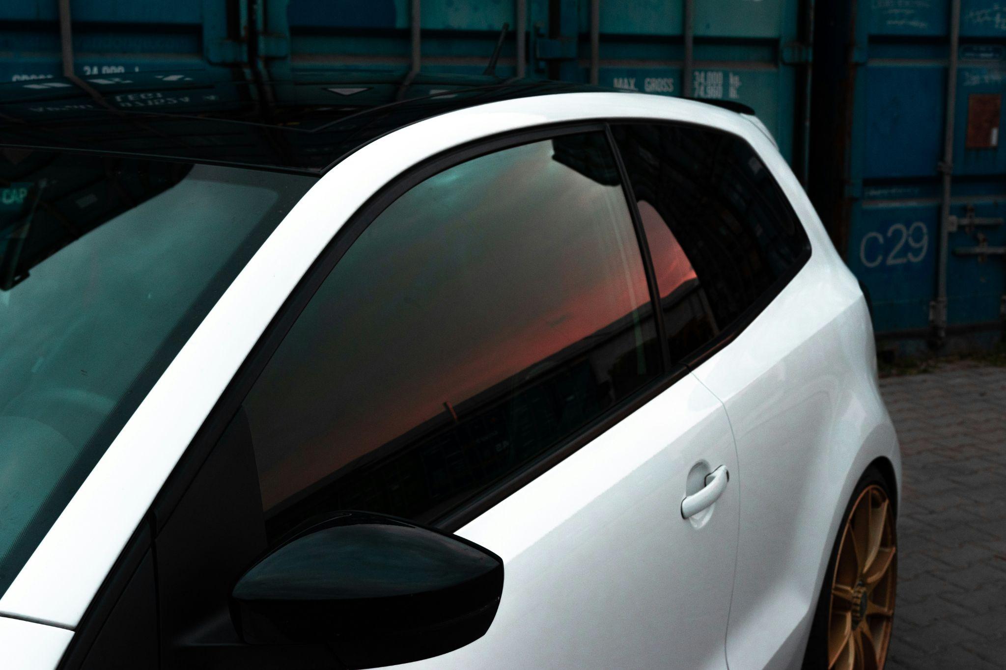 A sleek vehicle with tinted side windows reflecting the sunset, showcasing auto window tinting in Clovis.