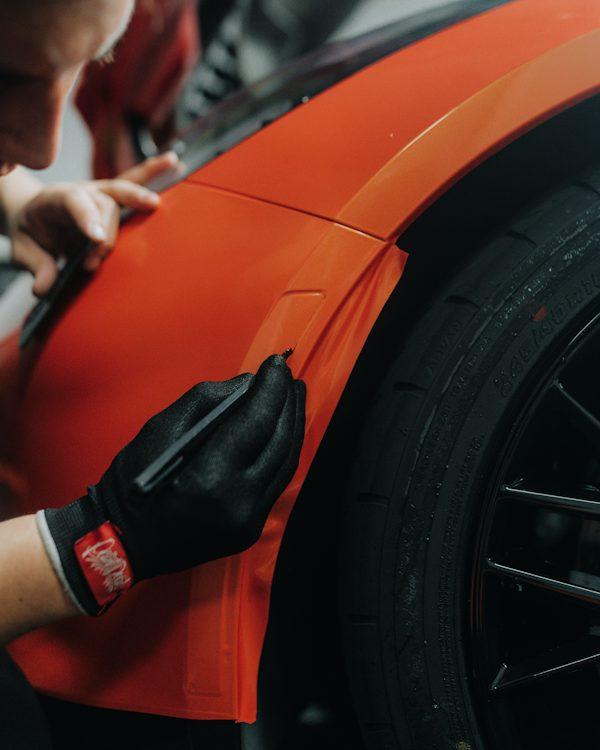 Technician performing car window tint installation in California on a vehicle side window.